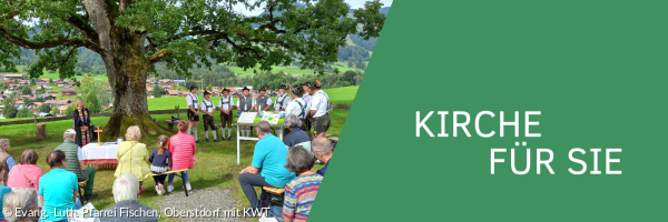 Gottesdienst im Grünen unter einem großen Baum auf einer Wiese.